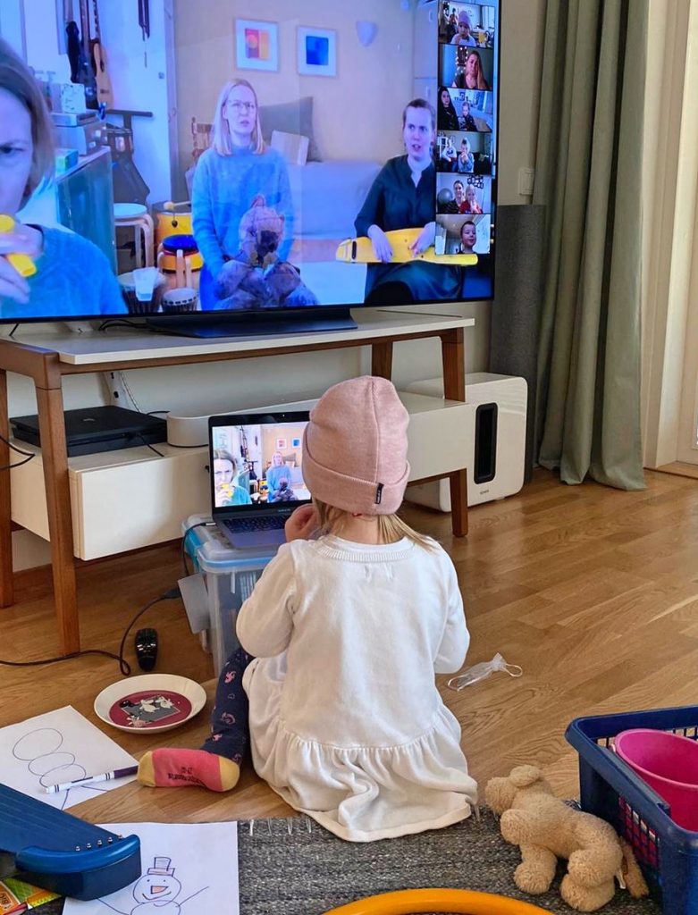 Kuvassa pieni lapsi istuu läppärin ja TV:n edessä, molemmissa ruuduissa näkyy CIsumusan ohjaajia